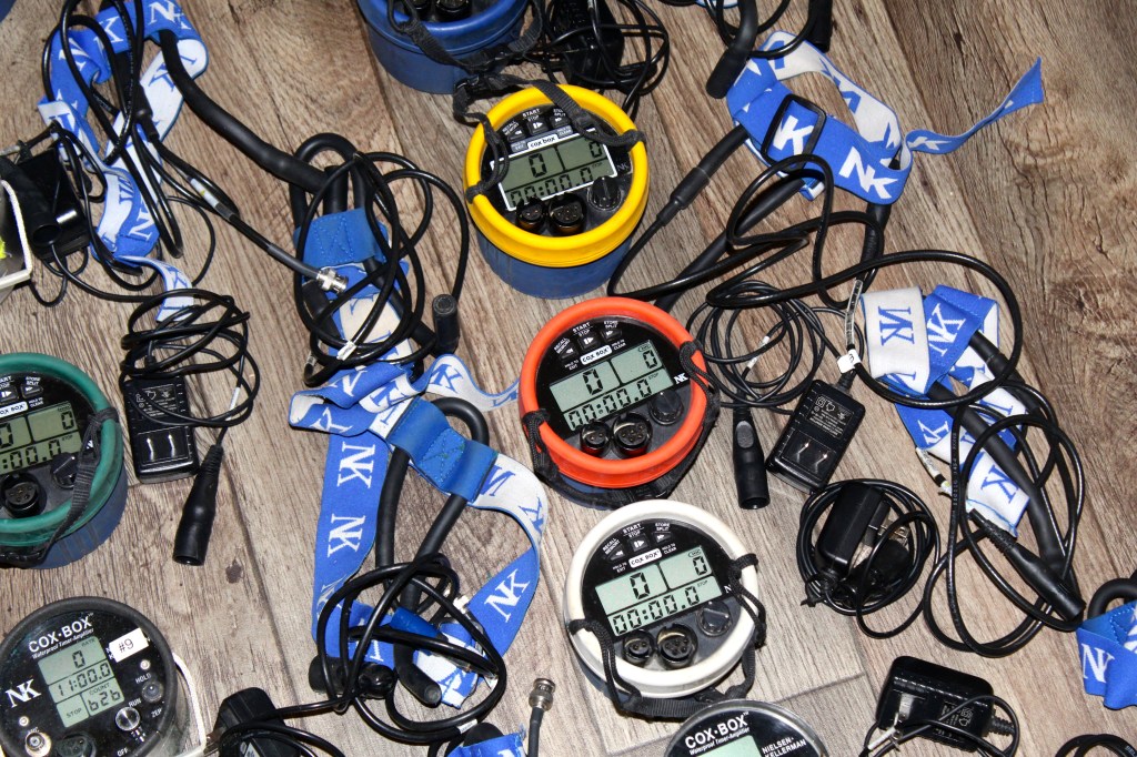 Cox boxes turned on lined up with headsets and chargers.